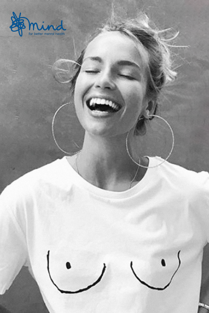 Iconic white Boob T-shirt with line drawing, worn by a laughing woman in support of Mind charity.