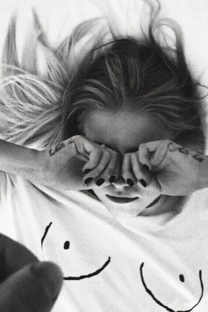 Iconic white Boob T-shirt with line drawing detail on a model lying down in black and white.