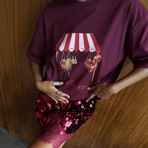 Burgundy Fruit Shop T-Shirt with a striped awning graphic, styled with a red sequin skirt and lace trim.