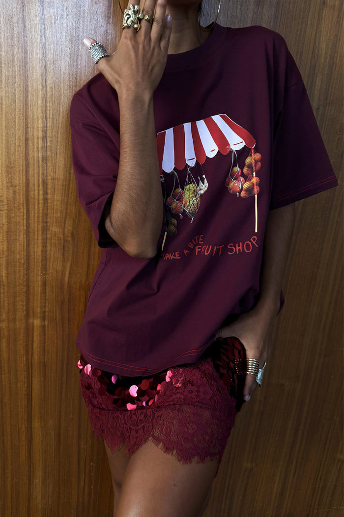Burgundy Fruit Shop T-shirt with a relaxed fit and dropped shoulders, styled with a red sequinned lace skirt.