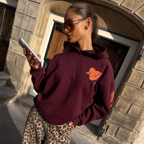 Burgundy Hoodie with Coral Embroidery on the chest and sleeve, styled with leopard print trousers and oversized sunglasses.
