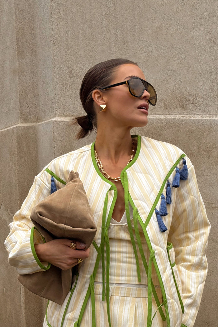 Butter Yellow Stripe Quilted Jacket with green trim and blue tassels, styled for a London look.