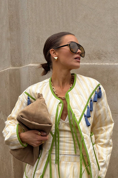 Butter Yellow Stripe Quilted Jacket with green trim and blue tassels, styled for a London look.