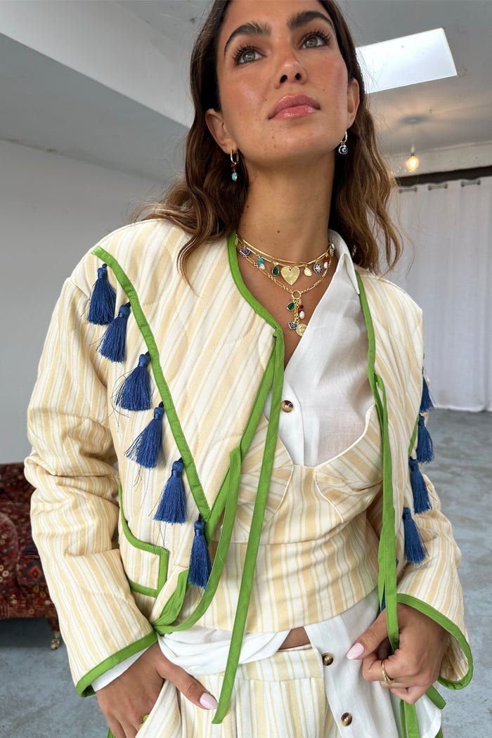 Butter Yellow Stripe Quilted Jacket with green trim and blue tassels, worn over a matching top and white shirt.