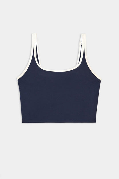 The SPLITS59 Cait Rigor Bralette in Indigo/White features white trim on the straps and neckline and is crafted from soft nylon spandex fabric, shown against a plain white background.