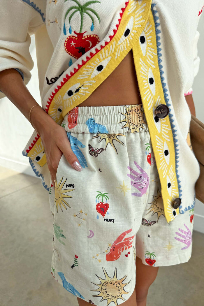 Celestial Ellie Shorts in cream cotton-linen, featuring an elasticated waistband and colourful sun and heart prints.
