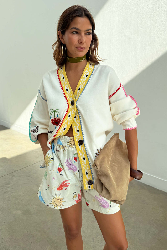 Cream Celestial Ellie Shorts in cotton-linen with sun and heart motifs, paired with a patterned cardigan.
