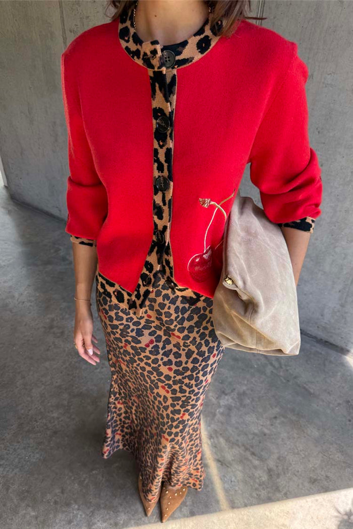 Red Cherry Holly Cardigan with leopard print trim and cherry motifs, styled with a leopard print skirt and suede bag.
