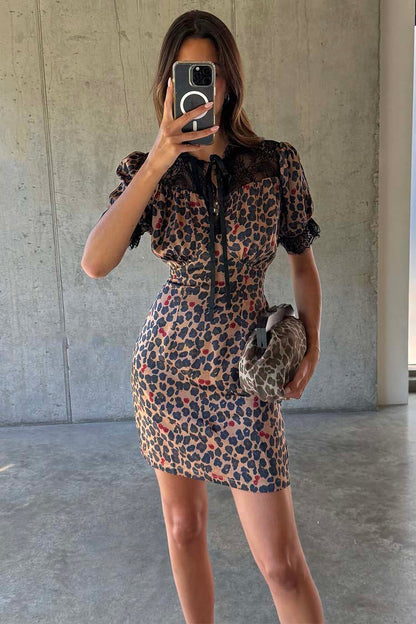 Cherry Leopard Mini Lyla Dress featuring black lace trim, tie neck and cherry print, shown in a mirror selfie.