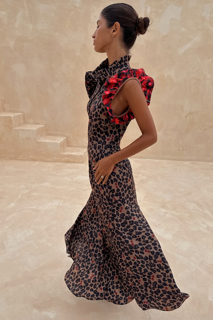 Cherry Leopard Remi midaxi dress with pleated frills on the neckline and red frill sleeves against stone stairs.