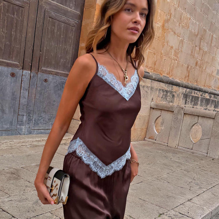 Chocolate Aurelia Top in brown satin with blue lace trim, V-neckline and pointed hem, styled outdoors.