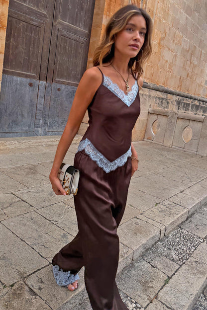 Chocolate Aurelia satin-esque top with blue lace trim, styled with matching trousers on a model walking outdoors.