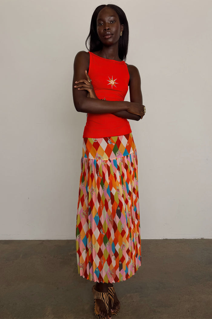 Cirque Beatrice Skirt in a colourful harlequin geometric print with a pleated A-line midi silhouette on a model.