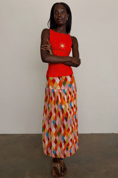 Cirque Beatrice Skirt in a colourful harlequin geometric print with a pleated A-line midi silhouette on a model.