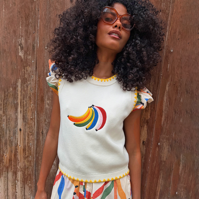 Cream Banana Tank in a knit with a colourful embroidered motif and yellow scalloped edges on a model.