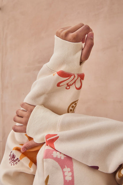 Cream Sundazed Accessible Hoodie by NFD x Porto & Bello with a sun print and thumb holes, designed in London.