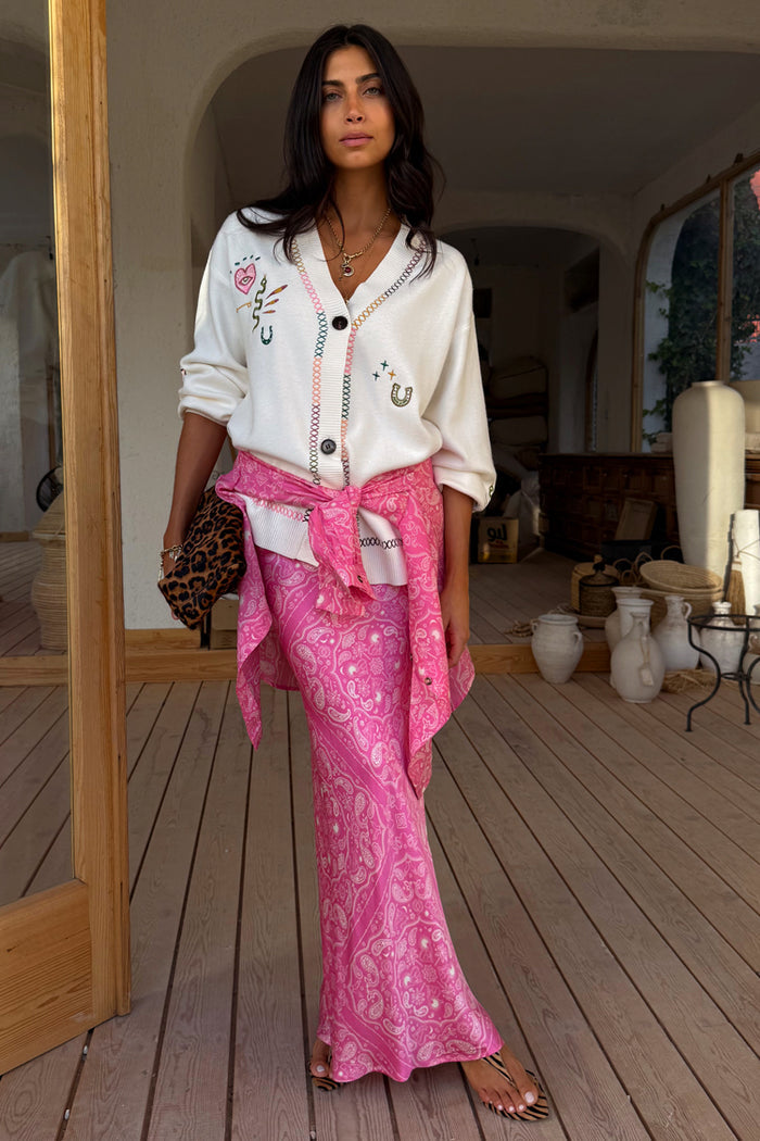 Cream Western Martha Cardigan with western motifs, styled with a pink paisley skirt and leopard bag.