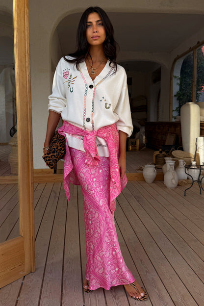 Cream Western Martha Cardigan with western motifs, styled with a pink paisley skirt and leopard bag.
