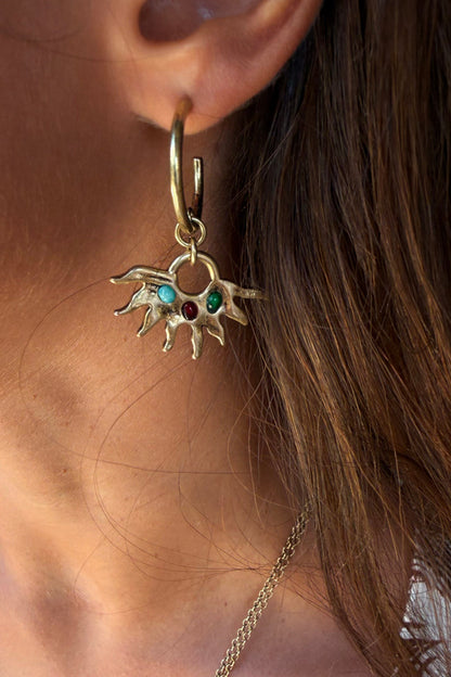 Gold-tone Deloris Sun Hoop Earrings featuring iconic sun motifs and semi-precious stones, worn on the ear.