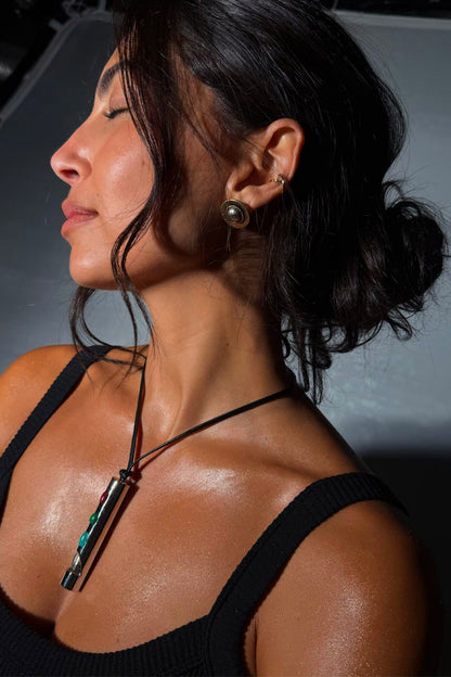 Deloris Whistle Necklace with a brass pendant and multi-coloured stones on an adjustable leather cord.