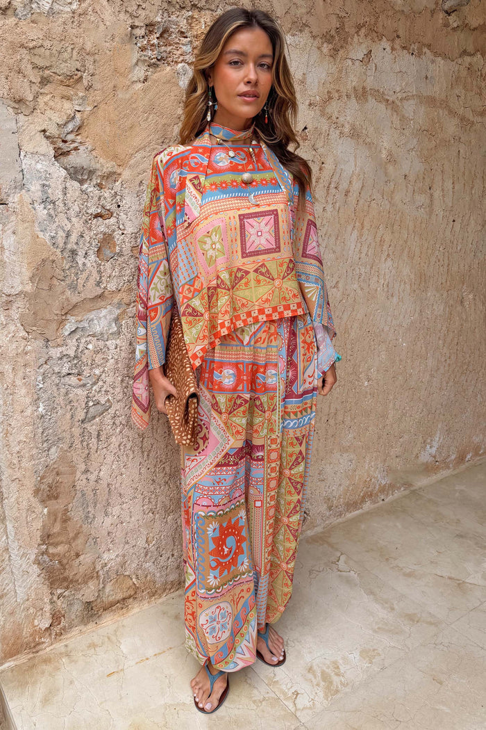 Dolce Vita Cape Top in a pastel patchwork tile print with an asymmetric hem, fluid sleeves and matching scarf.