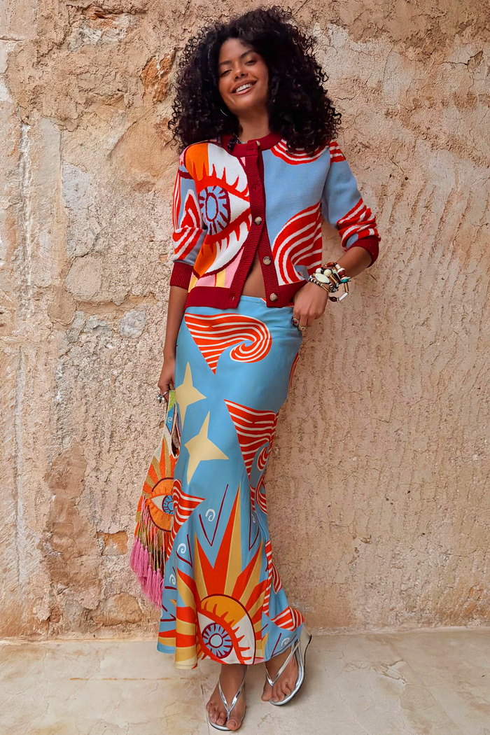 Dolce Vita Dorris Skirt in blue with sun and star motifs, styled with a matching cardigan and silver sandals.