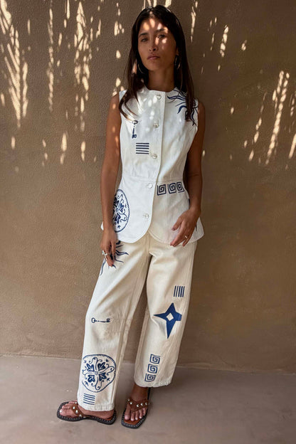 Dolce Vita Embroidered Denim Barrel Leg Jeans in cream featuring blue sun motifs and Greek-inspired graphics.