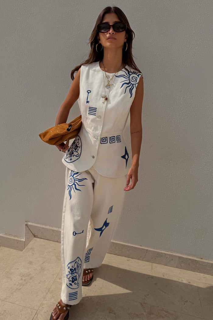 Dolce Vita ecru denim co-ord with blue Greek-inspired motifs, featuring barrel leg jeans and matching waistcoat.