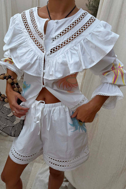 White cotton Dreamer Ellie Shorts with sun motifs and a cut-out hem, styled as a co-ord with the matching shirt.