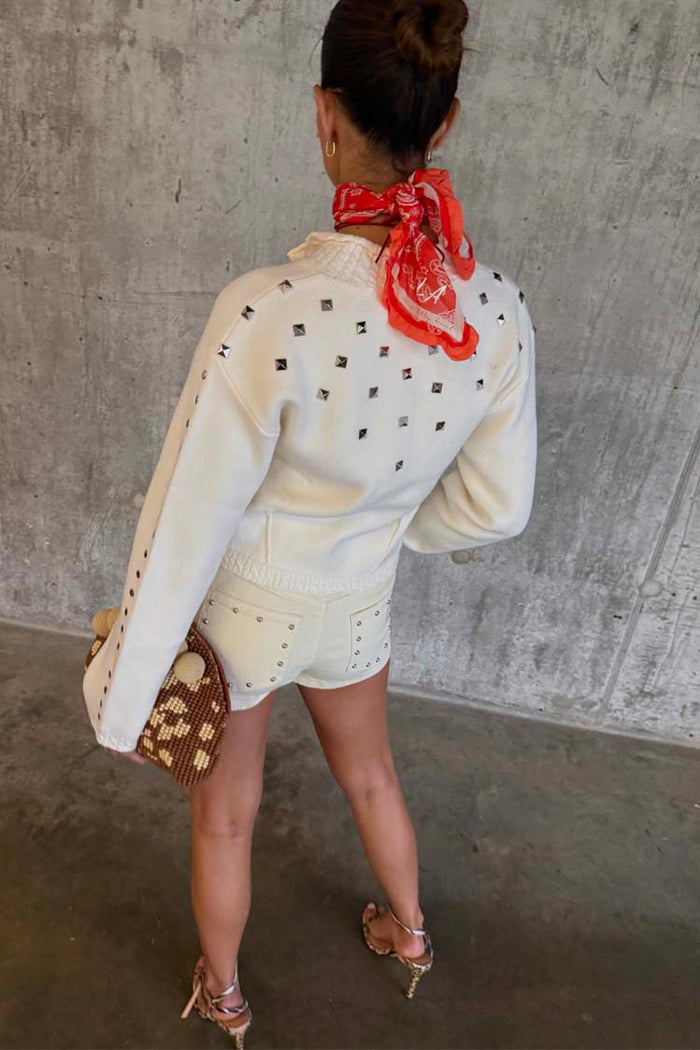 Ecru Studded Cardigan with silver metal studs on the back and sleeves, paired with matching denim shorts.