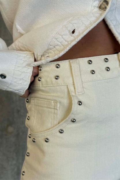 Ecru Studded Hot Pants in cream denim featuring silver stud detailing on the waistband and front pocket.
