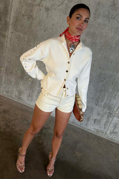 Ecru Studded Hot Pant with silver studs, styled with a matching jacket and red bandana neckerchief.