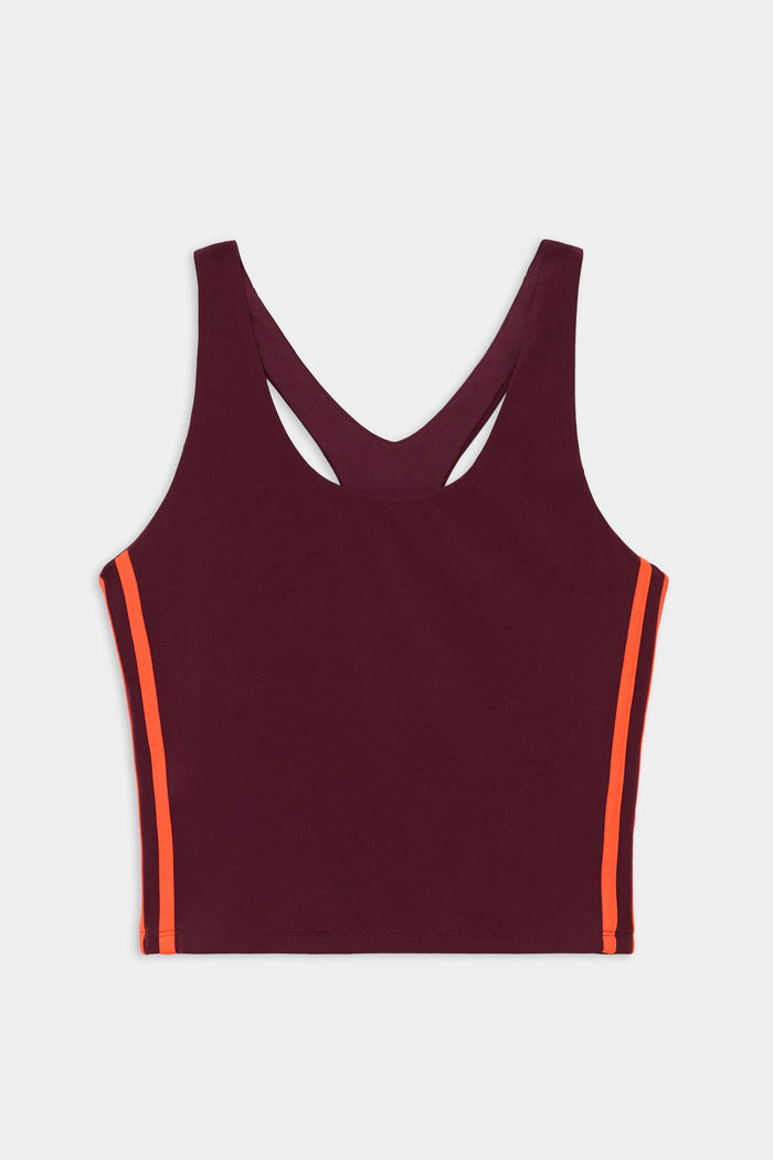 The SPLITS59 Ella Airweight Tank in Dark Cherry/Valencia is a sleeveless racerback crop top with orange side stripes, crafted from a nylon-spandex blend, shown against a white background.
