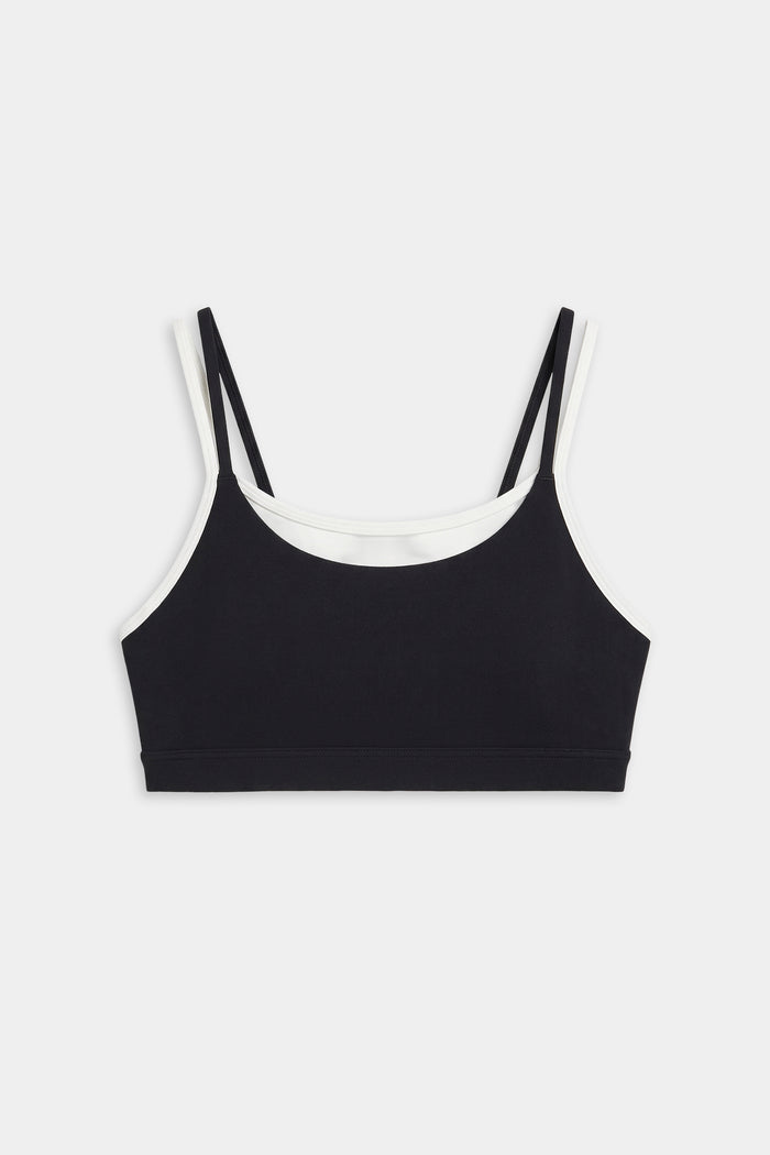The SPLITS59 Elliah Airweight Double Layer Bra in black/white features double shoulder straps, white trim, and a soft spandex-nylon blend, shown on a plain white background.