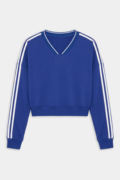 The SPLITS59 Ellie Fleece V Neck Sweatshirt in Cobalt/White features a cropped fit, long sleeves with white double stripes, and a V-neck collar—ideal for an athletic look.