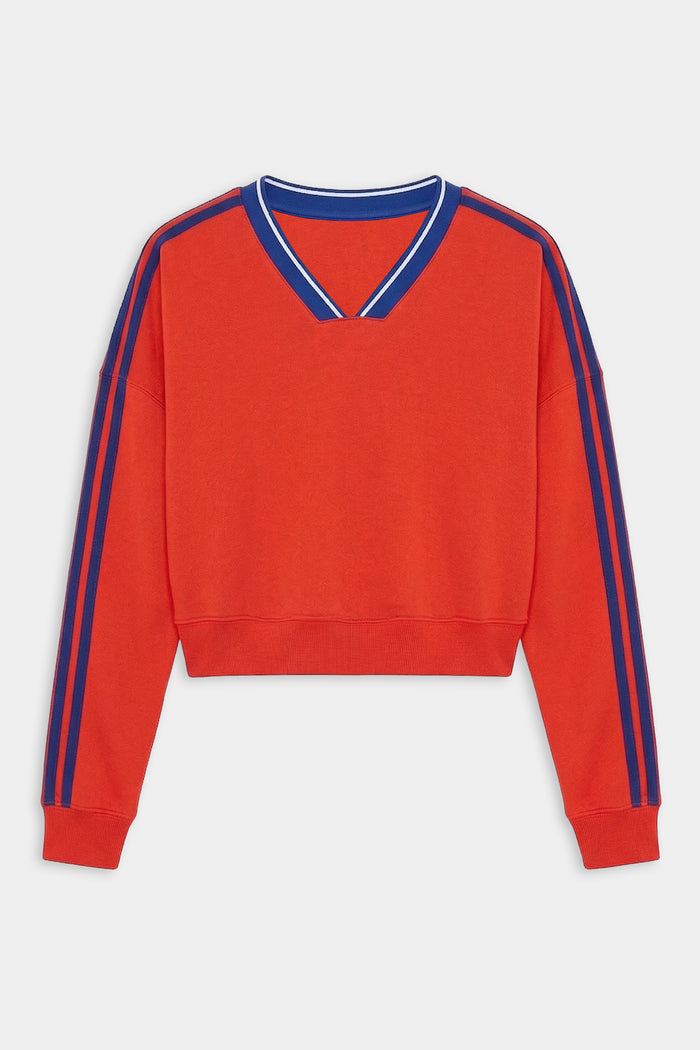The SPLITS59 Ellie Fleece V Neck Sweatshirt in Lotus Red/Cobalt features blue double stripes on the shoulders and sleeves, a blue-trimmed V-neck, and is made from a soft spandex blend for comfort and stretch.