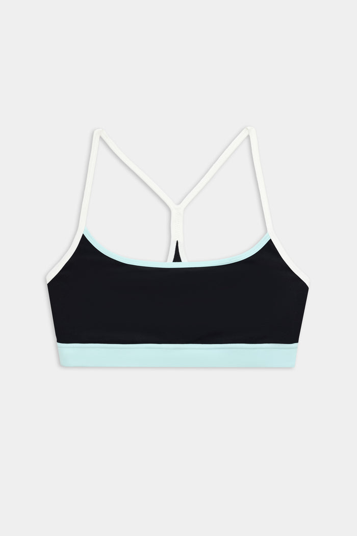 The SPLITS59 Emerson Airweight Bra in Black/Ice features thin white straps and a light blue band, ideal for Pilates or hot yoga. Shown against a plain white background.