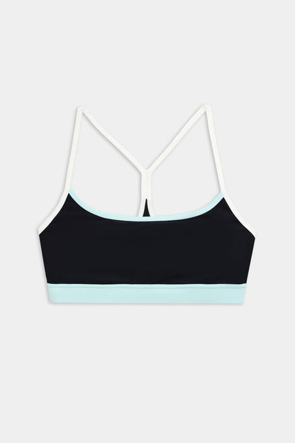The SPLITS59 Emerson Airweight Bra in Black/Ice features thin white straps and a light blue band, ideal for Pilates or hot yoga. Shown against a plain white background.