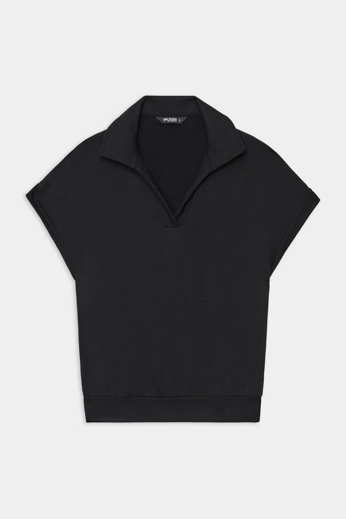 The SPLITS59 Evie Fleece Sleeveless Polo in black features a collared V-neck and loose fit, crafted from a soft modal spandex blend. Displayed on a plain white background.