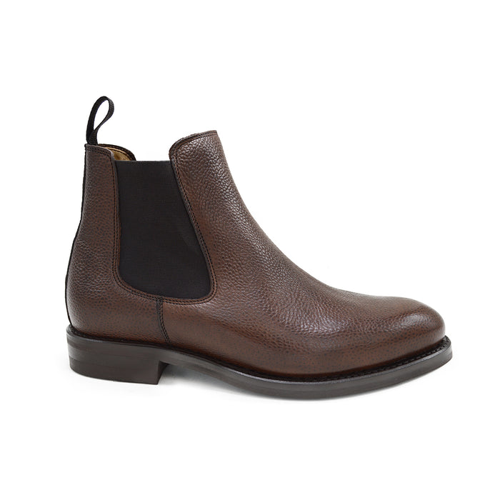 A dark brown grain leather Chelsea boot with a black elastic side panel and a round toe. The boot has a low heel and a goodyear welted dainite rubber sole.