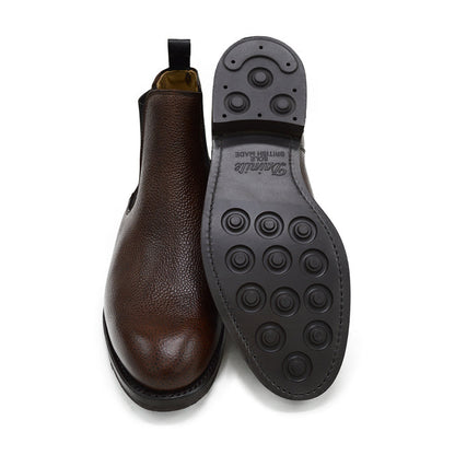 A dark brown grain leather Chelsea boot with a black elastic side panel and a round toe. The boot has a low heel and a goodyear welted dainite rubber sole.