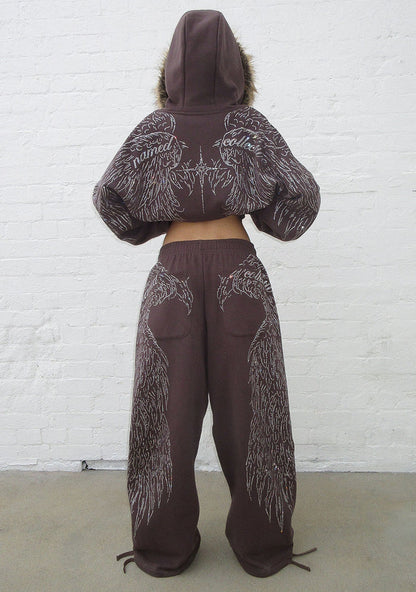Model wearing brown sweatpants showcasing rhinestone wing design and two back pockets from the back view.
