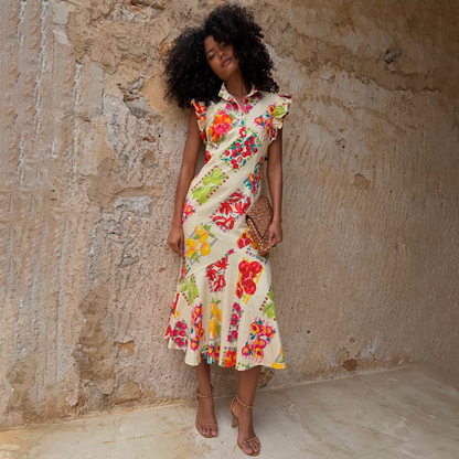 Fruit Stamps Remi midi dress with a fruit sticker print, ruffle sleeves and a buttoned collar on a model.
