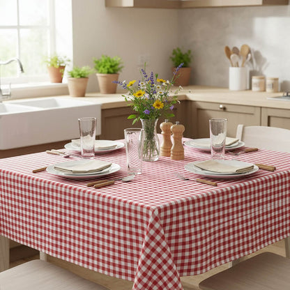 Dining table set with a red and white checkered tablecloth in a kitchen.