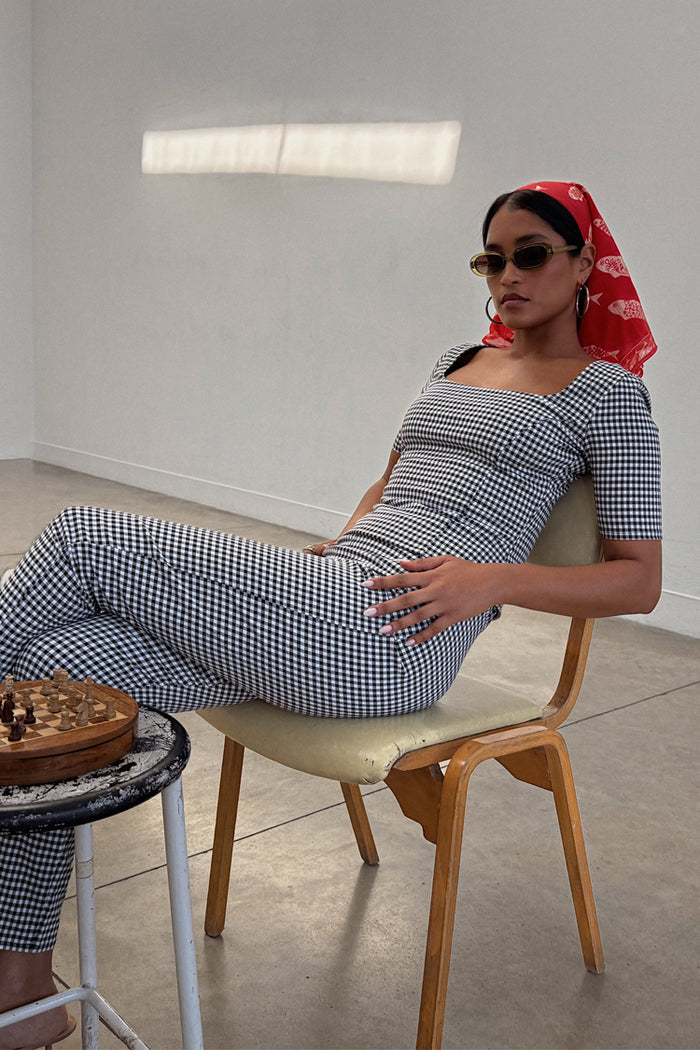 Gingham Top in black and white with a square neckline, styled as a co-ord with matching trousers and a red headscarf.