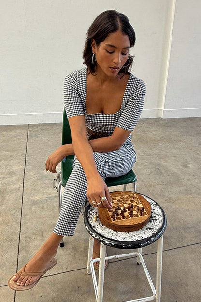 Gingham Top with a deep square neckline in a black and white check, styled as a co-ord while playing chess.