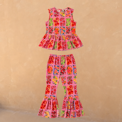 Girl's pink fruit print set with a sleeveless peplum top and matching frilled flared trousers in 100% cotton.