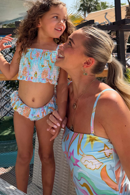 Blue Starburst Crop Bikini Set with a smocked top and frill trims on a girl for a matching family vacation look.
