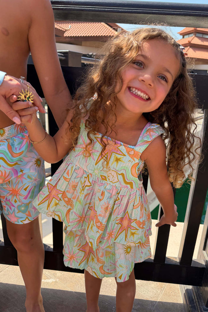 Starburst Skirt Co-ord Set in blue cotton with a sun and star print, worn by a smiling girl.
