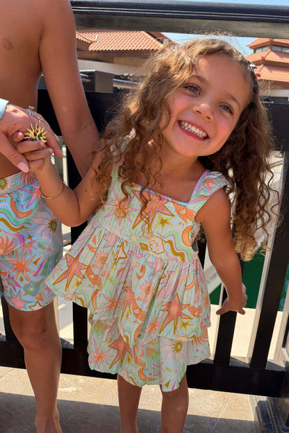 Starburst Skirt Co-ord Set in blue cotton with a sun and star print, worn by a smiling girl.